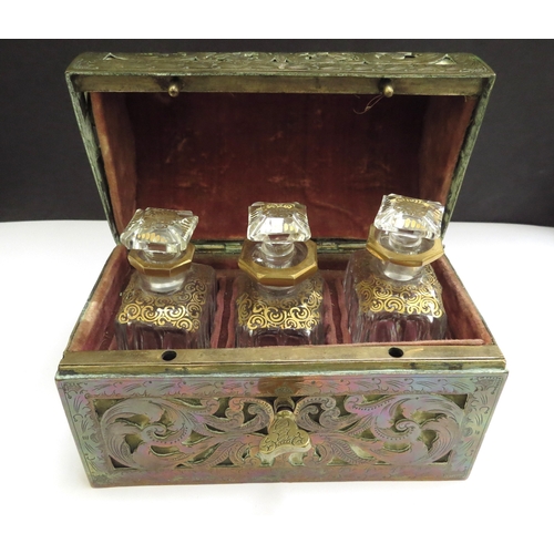 6336 - A domed shaped pierced brass velvet lined perfume casket containing three fitted cut glass perfume b... 