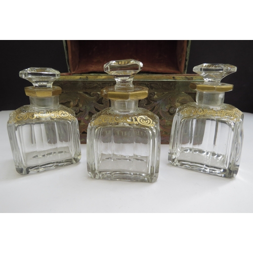 6336 - A domed shaped pierced brass velvet lined perfume casket containing three fitted cut glass perfume b... 