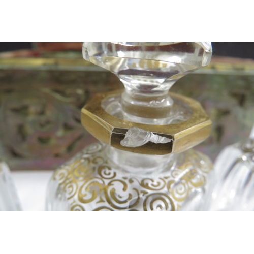 6336 - A domed shaped pierced brass velvet lined perfume casket containing three fitted cut glass perfume b... 