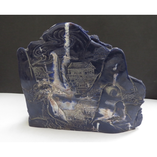 6343 - A Chinese boulder carving depicting a mountain scene, 15cm tall, 18cm wide