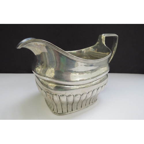 6485 - An early 19th Century Irish silver milk jug, stirrup handle and fluted detail, sea creature designed... 