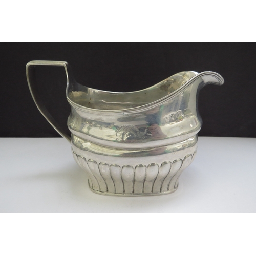 6485 - An early 19th Century Irish silver milk jug, stirrup handle and fluted detail, sea creature designed... 