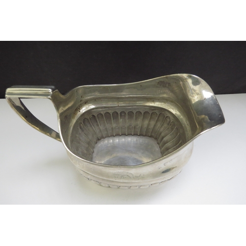 6485 - An early 19th Century Irish silver milk jug, stirrup handle and fluted detail, sea creature designed... 