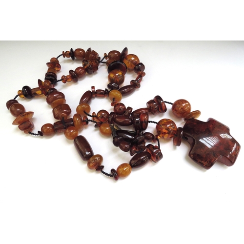 6487 - A large bead amber necklace with a large pendant,110cm long, 138g  (R)  £140