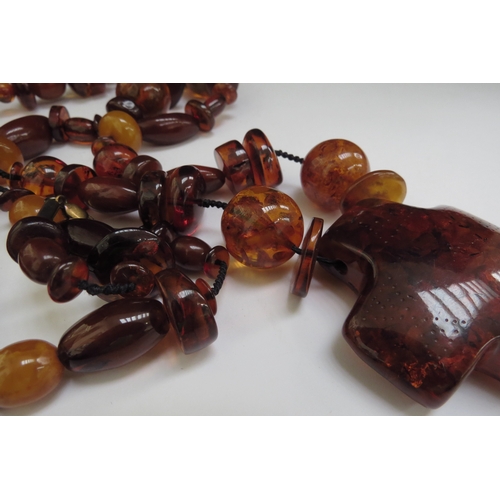 6487 - A large bead amber necklace with a large pendant,110cm long, 138g  (R)  £140