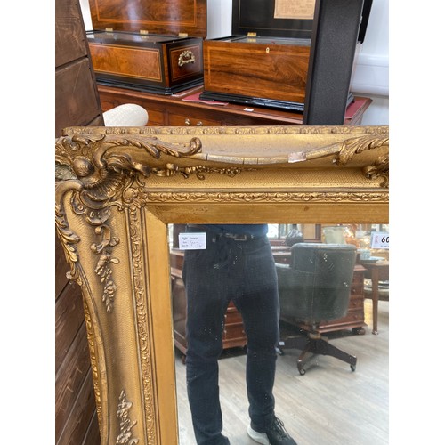 6053 - A highly ornate gilt hall mirror, small bits of gesso missing, 117cm x 85cm