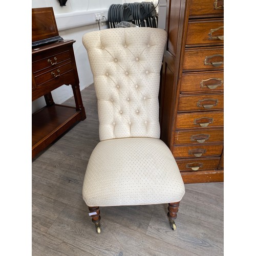 6104A - A Victorian button back nursing chair with oak legs to castors, 96cm tall x 50cm wide  (R)  £40