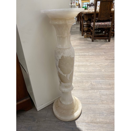 6250 - A carved onyx pedestal 82.5cm tall