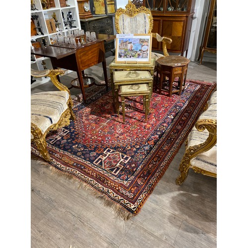 6510 - A hand-knotted middle-eastern carpet, red ground, multiple borders in navy, 175cm x 259cm