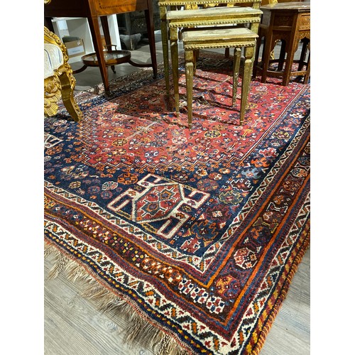 6510 - A hand-knotted middle-eastern carpet, red ground, multiple borders in navy, 175cm x 259cm