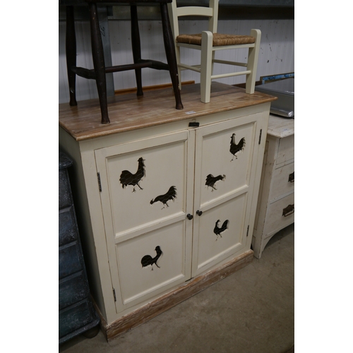 2316 - A cream two door cupboard fret cut with chickens and a rush seated child's chair     (R) £40