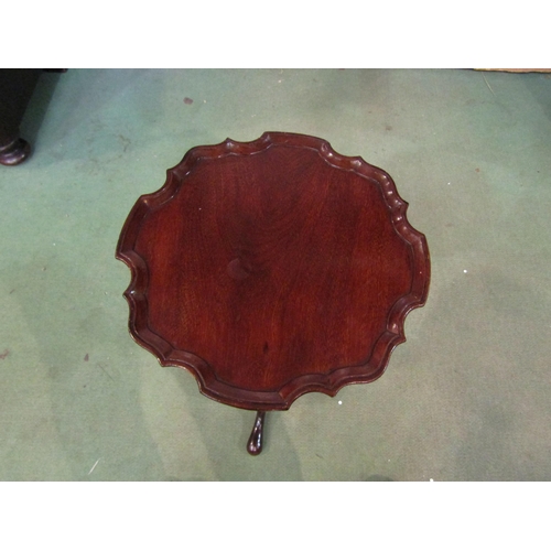 4011 - A George III style mahogany wine table the piecrust edge top over a turned and fluted column on a tr... 