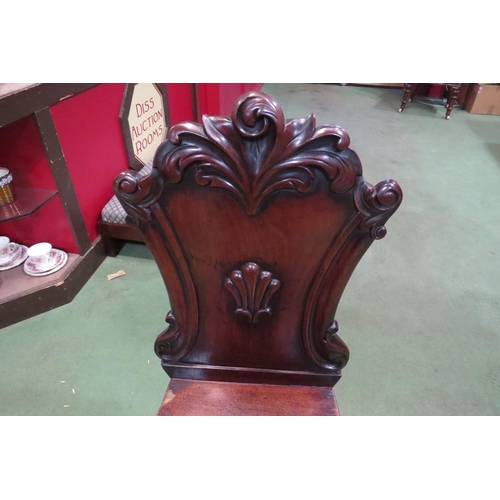 4002 - A circa 1840 mahogany hall chair, the carved back rest over turned and tapering fore legs, 91cm long... 