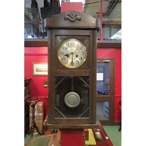 4068 - An early 20th Century oak cased wall clock, with key and pendulum