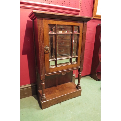 4096 - A late Victorian oak cabinet, the bevelled mirrored glass single door over an undertier held by turn... 