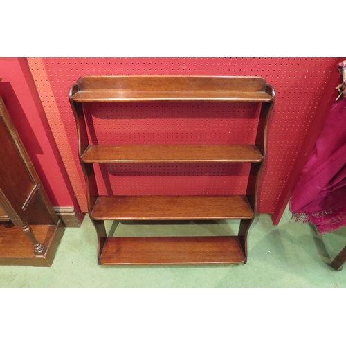 4100 - A set of four tier mahogany shelves with wavy sides, 79cm tall x 68cm wide x 17cm deep