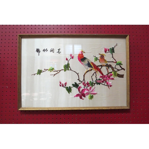 4114 - A Chinese silk embroidered textile depicting exotic birds and flowering foliage, framed and glazed, ... 