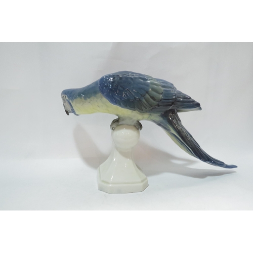 4127 - A Royal Dux figurine of a Blue Macaw parrot upon perch, 20cm high x 38.5cm long