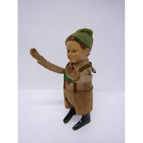 8236 - A Schuco clockwork tinplate figure of a Tyrolean boy in felt outfit, arms move when wound, 13cm tall