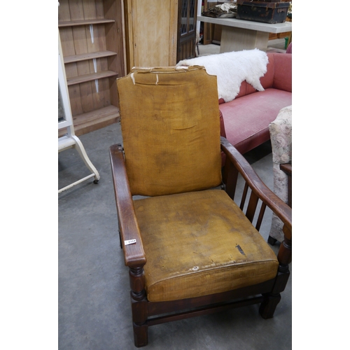 2446 - A 1930's oak recyling armchair with folds out into a bed