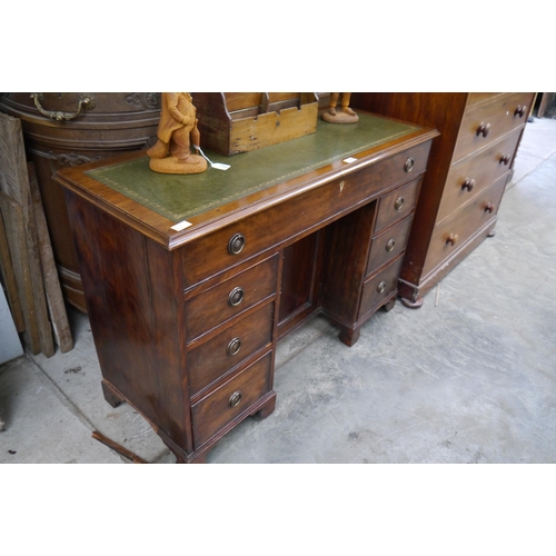 2085 - An Edwardian mahogany seven drawer desk with green leather top