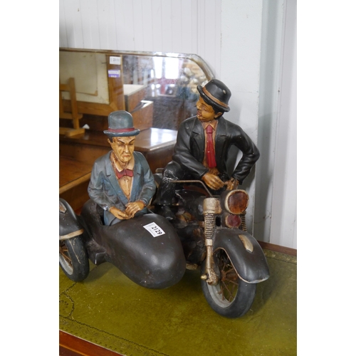 2129 - A resin figural group Laurel & Hardy on motorbike and side-car