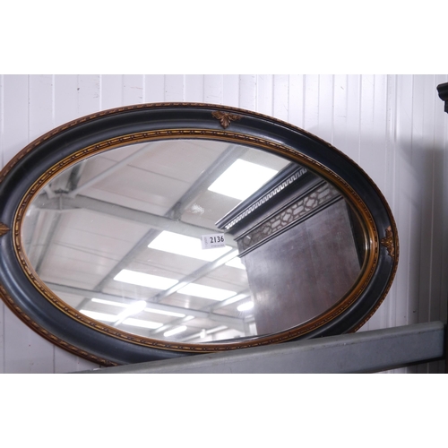 2136 - An Edwardian oval black and gold mirror