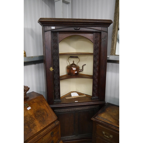 2159 - A 19th Century country oak full height corner cabinet, concave shelves over single door cupboard bas... 