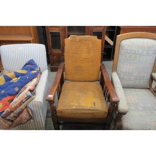 2446 - A 1930's oak recyling armchair with folds out into a bed