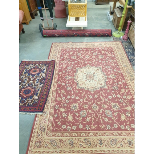 2450 - A rust coloured carpet 277cm x 190cm and an Eastern rug three guls, maroon ground, 135cm x 84cm (2)