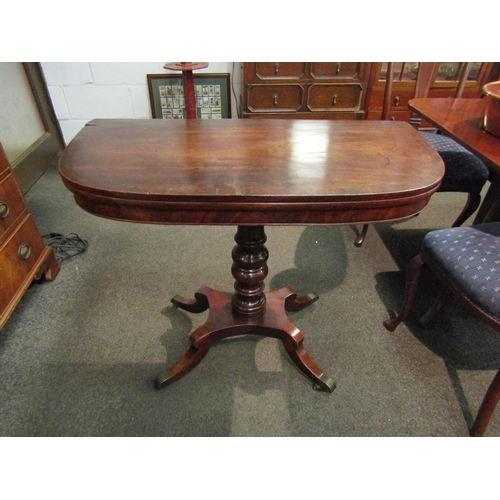 1147 - A George III flame mahogany crossbanded D-shape fold over table on a turned column and plateau base,... 