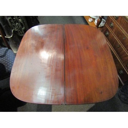 1147 - A George III flame mahogany crossbanded D-shape fold over table on a turned column and plateau base,... 