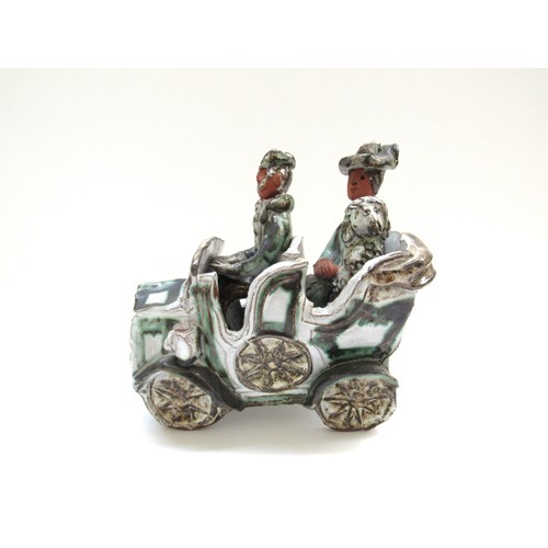 9045 - A Marie Whitby Seven Springs pottery 'figures in a car' , label to base, 19.5cm x 19cm x 13cm