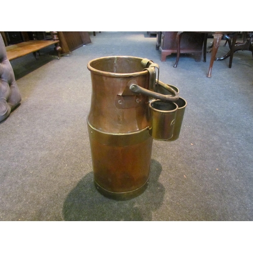 1002 - A copper and brass milk churn with three graduating measures from two pint to half pint, 41cm tall