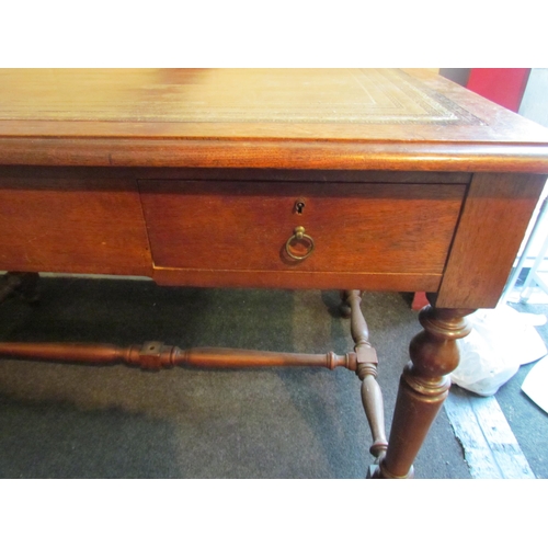 1008 - An early 20th Century desk, the tooled leather top over two frieze drawers, turned supports joined b... 