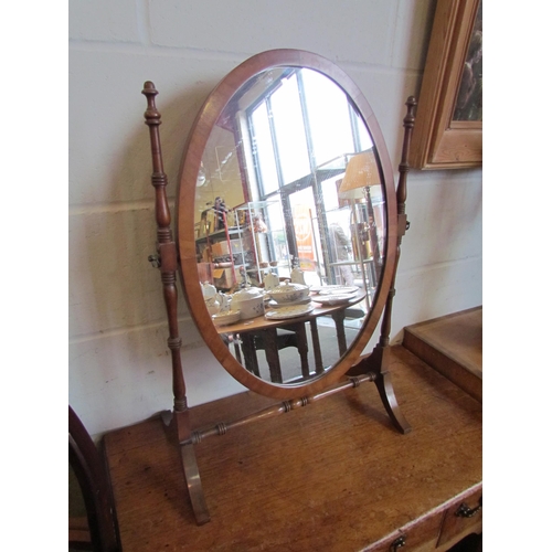 1021 - A dressing table mirror, oval glass, slender spindle supports, 68cm tall