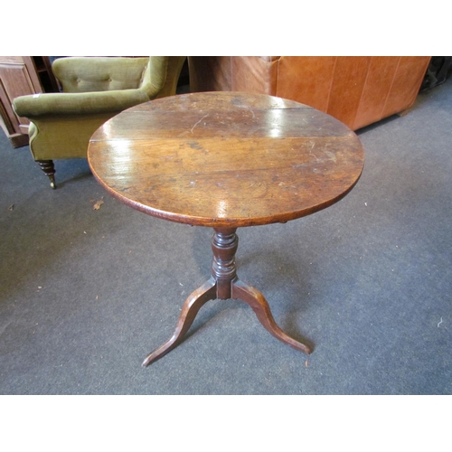 1030 - A Georgian country oak wine table, the circular top over a turned column to a tripod base, 75cm tall... 