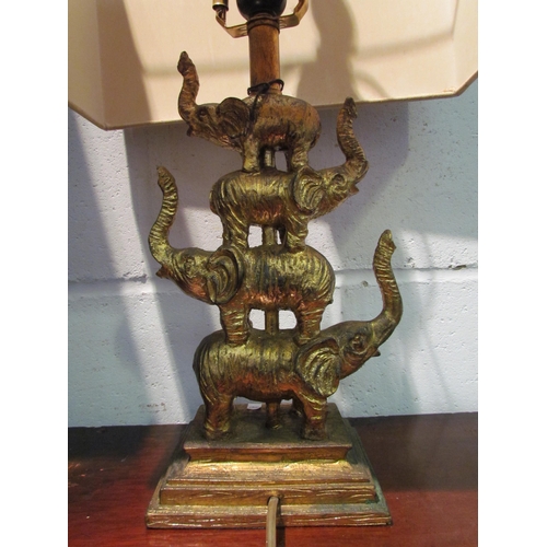 1032 - A gilt table lamp in the form of four stacked elephants, with shade