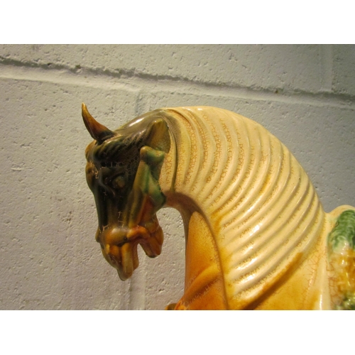 1033 - A Tang style horse, tan and green glazed pottery, 33cm tall