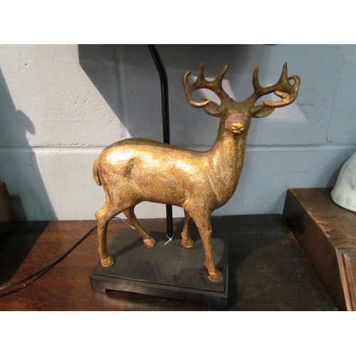 1053 - A table lamp base with gilt stag design, black shade, 66cm tall including shade