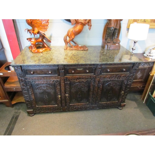 1107 - A Victorian carved oak dresser base with later marble top over three drawers and three door cupboard... 