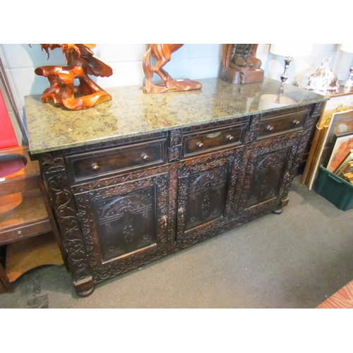 1107 - A Victorian carved oak dresser base with later marble top over three drawers and three door cupboard... 