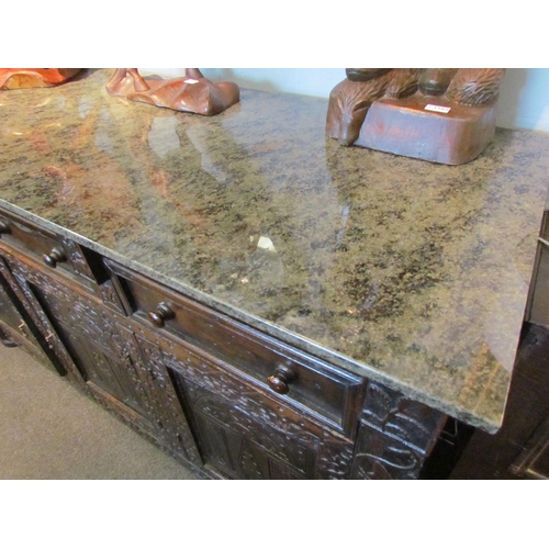 1107 - A Victorian carved oak dresser base with later marble top over three drawers and three door cupboard... 