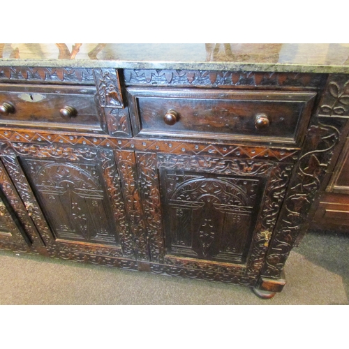 1107 - A Victorian carved oak dresser base with later marble top over three drawers and three door cupboard... 