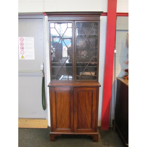 1111 - A Regency mahogany bookcase, the astragal glazed top over a two door cupboard base, split to top, 20... 