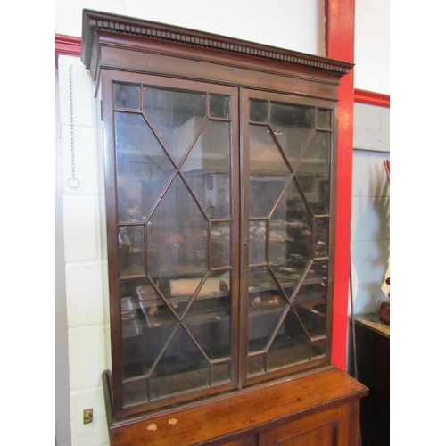 1111 - A Regency mahogany bookcase, the astragal glazed top over a two door cupboard base, split to top, 20... 