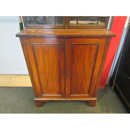 1111 - A Regency mahogany bookcase, the astragal glazed top over a two door cupboard base, split to top, 20... 