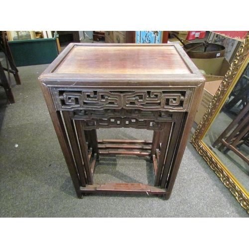 1123 - A 19th Century Chinese hardwood nest of four tables, geometric frieze, largest 66cm tall x 47cm wide... 