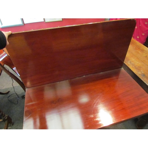 1145 - A Victorian flame mahogany tea table, the fold-over top over a faceted column to a quatreform base