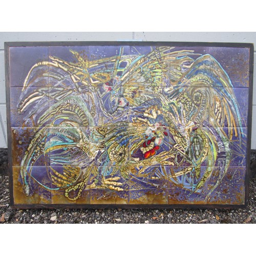 9487 - A tiled wall panel depicting fighting cockerels in colours, on a purple and ochre ground. Framed wit... 